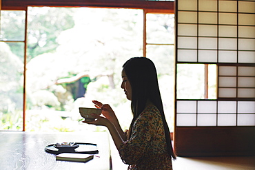 Japanese woman drinking green tea in a traditional Japanese house