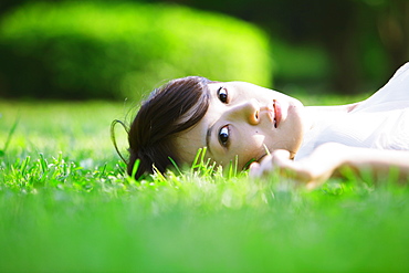 Young Woman Lying on Grass In Park