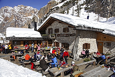 Guests sitting on terrace of the hut Scotoni in sunshine, South Tyrol, Italy