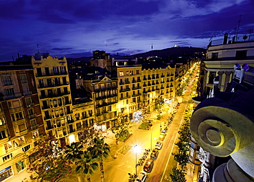 View of buildings and street lights at evening in Gracia, Barcelona, Spain