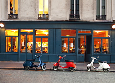 Row of vespas parked against exterior of Cafe Marly Restaurant, Paris