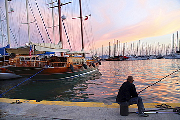 Man fishing at harbor at sunset in Bodrum Peninsula, Turkey