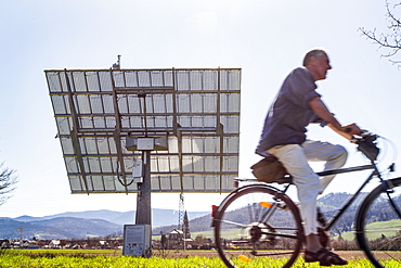 View of cyclist and solar module along Soitec Landscape, St. Georgen, Freiburg, Germany