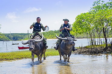 Armed policemen on buffalo back on Marajo Island in the Brazilian Amazon, Para, Brazil, South America