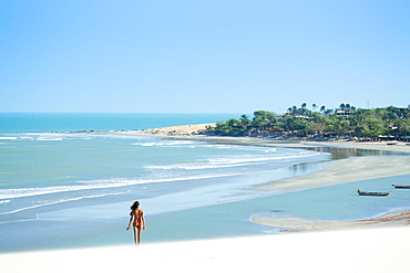 A young woman walking along the beach in Jericoacoara, Ceara, Brazil, South America
