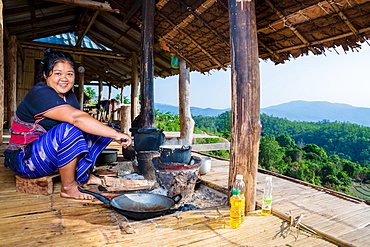 Indigenous White Karen (Kayin) hill tribe villager cooking at a traditional stove in a mountain village near Doi Inthanon, Chiang Mai, Thailand, Southeast Asia, Asia