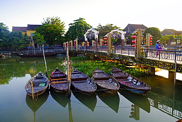 Boats on the Thu Bon River with a cyclist on the Lantern Bridge in Hoi An, UNESCO World Heritage Site, Quang Nam, Vietnam, Indochina, Southeast Asia, Asia