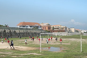 Children playing football outside the Spanish colonial city walls of Cartagena in the Colombian Caribbean, Cartagena, Colombia, South America