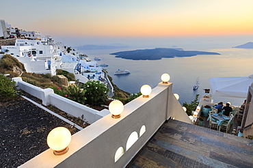 The fiery red sky on the Aegean Sea after sunset seen from the typical terraces of Firostefani, Santorini, Cyclades, Greek Islands, Greece, Europe