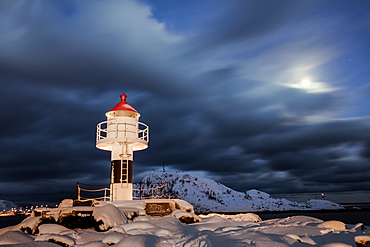 Lighthouse and full moon in the Arctic night with the village of Reine in the background, Nordland, Lofoten Islands, Arctic, Norway, Scandinavia, Europe