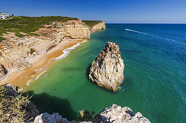 The turquoise waters of the ocean frames the sandy beach of Praia do Torrado, Algarve, Lagoa, Faro District, Portugal, Europe