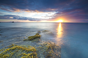 The lights of sunset are reflected in the blue sea Hawksbill Bay, Antigua, Antigua and Barbuda, Leeward Islands, West Indies, Caribbean, Central America