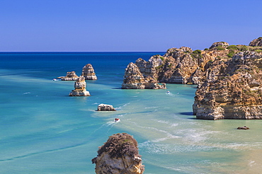 The turquoise water of the Atlantic Ocean and cliffs surrounding Praia Dona Ana beach, Lagos, Algarve, Portugal, Europe