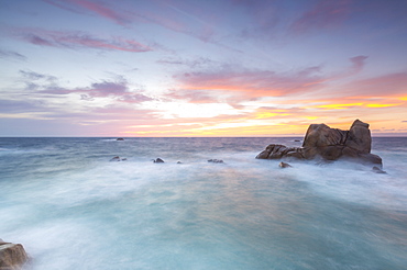 The fiery sky frames the waves crashing on rocks, Capo Testa, Santa Teresa di Gallura, Province of Sassari, Sardinia, Italy, Mediterranean, Europe