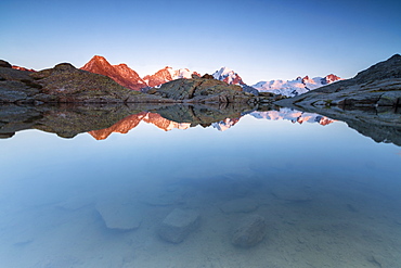 Snowy peaks reflected in the alpine lake at sunset, Fuorcla, Surlej, St. Moritz, Canton of Graubunden, Engadine, Switzerland, Europe