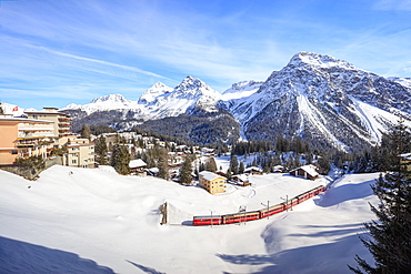 Red train of Rhaetian Railway passes in the snowy landscape of Arosa, district of Plessur, Canton of Graubunden, Swiss Alps, Switzerland, Europe