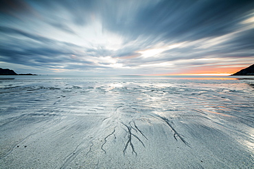 Midnight sun and clouds frame the sandy beach of Skagsanden, Flakstad, Nordland county, Lofoten Islands, Norway, Scandinavia, Europe