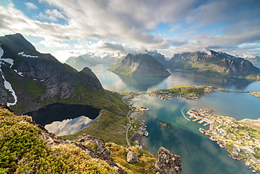 Clouds reflected in blue lake and sea framed by rocky peaks, Reinebringen, Moskenesoya, Lofoten Islands, Norway, Scandinavia, Europe