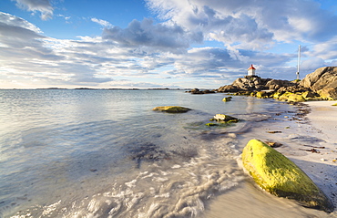 Midnight sun lights up cliffs and sandy beach surrounded by turquoise sea, Eggum, Unstad, Vestvagoy, Lofoten Islands, Norway, Scandinavia, Europe