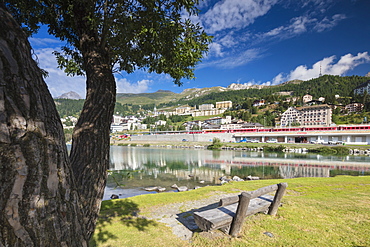 Bernina Express train runs past the village of St. Moritz surrounded by lake, Canton of Graubunden, Engadine, Switzerland, Europe