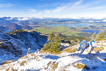 Hikers on steep crest covered with snow in the Ammergau Alps, Tegelberg, Fussen, Bavaria, Germany, Europe