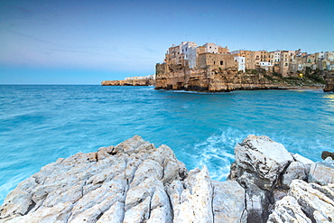 Turquoise sea at dusk framed by the old town perched on the rocks, Polignano a Mare, Province of Bari, Apulia, Italy, Europe