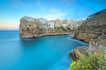 Turquoise sea at sunset framed by the old town perched on the rocks, Polignano a Mare, Province of Bari, Apulia, Italy, Europe