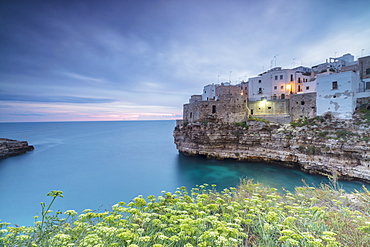 Turquoise sea at sunrise framed by the old town perched on the rocks, Polignano a Mare, Province of Bari, Apulia, Italy, Europe