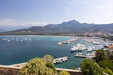 View of the harbor in the bay surrounded by the turquoise sea, Calvi, Balagne Region, northwest Corsica, France, Mediterranean, Europe