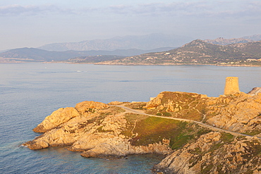 The ancient Genoese tower overlooking the blue sea surrounding the village of Ile Rousse, Balagne Region, Corsica, France, Mediterranean, Europe