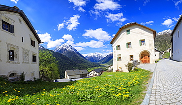 Panorama of alpine village framed by snowy peaks, Guarda, Inn District, Lower Engadine, Canton of Graudbunden, Switzerland, Europe