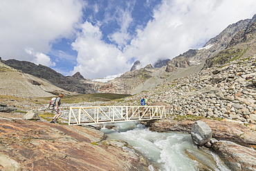 Hikers on walkway of the path Sentiero Glaciologico of Fellaria Glacier, Malenco Valley, Valtellina, Lombardy, Italy, Europe