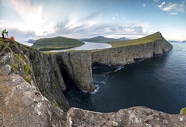 Panoramic of photographer on cliffs above lake Sorvagsvatn, Vagar Island, Faroe Islands, Denmark, Europe