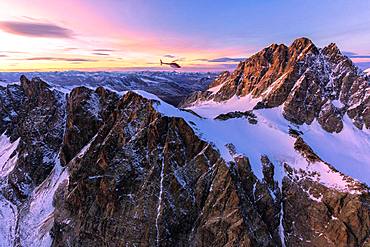 Aerial view of helicopter in flight towards Piz Roseg at sunset, Bernina Group, border of Italy and Switzerland, Europe