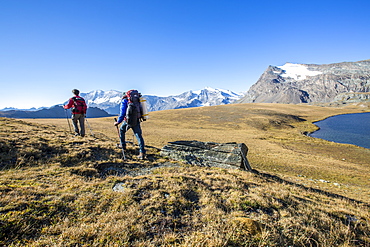 Hikers wallking along Rosset Lake, Gran Paradiso National Park, Alpi Graie (Graian Alps), Italy, Europe