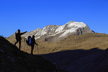 Hikers admire the view of Alpi Graie (Graian Alps) landscape, Gran Paradiso National Park, Italy, Europe