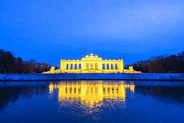 Illuminated Gloriette building mirrored in water at dusk, Schonbrunn Palace, UNESCO World Heritage Site, Vienna, Austria, Europe