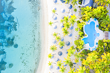 Swimming pool and beach umbrellas on white sand beach from above by drone, Morris Bay, Old Road, Antigua, Leeward Islands, West Indies, Caribbean, Central America