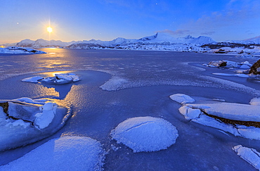 Reflections of full moon in the frozen sea, Lyngedal, Lofoten Islands, Arctic, Norway, Scandinavia, Europe