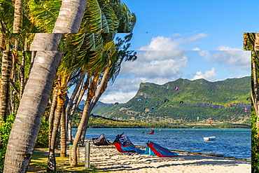 Kitesurf in the ocean seen from tropical palm-fringed beach, Le Morne Brabant, Black River district, Mauritius, Indian Ocean, Africa