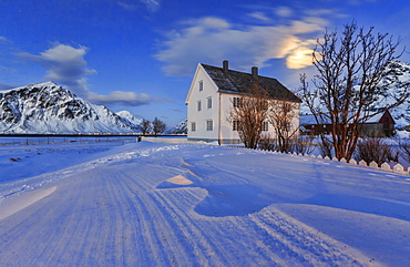 Typical house surrounded by snow on a cold winter day at dusk, Flakstad, Lofoten Islands, Norway, Scandinavia, Europe