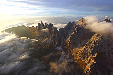 Aerial view of the mountain range of Odle surrounded by clouds in the Dolomites, Val Funes, Trentino-Alto Adige South Tyrol, Italy, Europe