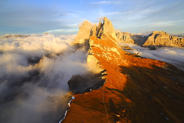 Aerial shot from Seceda of Odle surrounded by clouds at sunset in the Dolomites, Val Funes, Trentino Alto-Adige South Tyrol, Italy, Europe