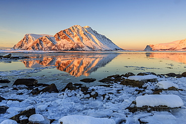 View of the mountains of Gymsoya (Gimsoya) from Smorten reflected in the clear partially frozen sea, Lofoten Islands, Arctic, Norway, Scandinavia, Europe