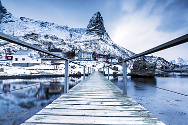 A bridge over the cold sea connects a typical fishing village. Reine, Lofoten Islands, Northern Norway, Scandinavia, Arctic, Europe