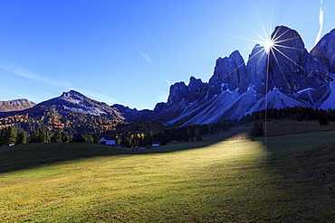 Green meadows and colorful woods in autumn frame the Odle, Malga Glatsch, Funes Valley, South Tyrol, Dolomites, Italy, Europe