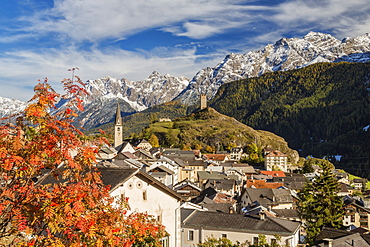 Autumn colors frame the village of Ardez surrounded by woods and snowy peaks, Engadine, Canton of Graubunden, Switzerland, Europe