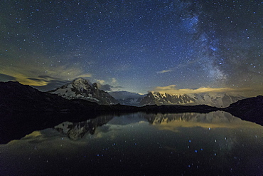 Stars and Milky Way illuminate the snowy peaks and Lac de Cheserys, Chamonix, Haute Savoie, French Alps, France, Europe