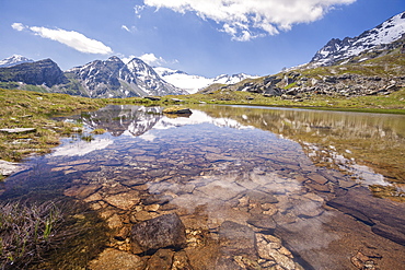 The snowy peaks are reflected in the clear waters of Lake Piz, La Margna, Fedoz Valley, Engadine, Switzerland, Europe