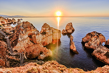 Golden sunrise on the red cliffs of Ponta Da Piedade, Lagos, Algarve, Portugal, Europe